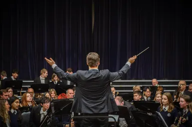 Nathan conducting, asking all members of the ensemble to stand for applause.