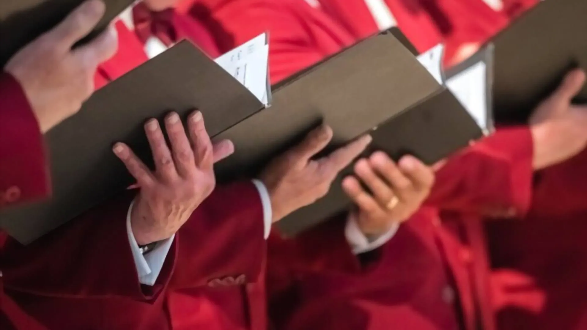 A few singers holding choral books.