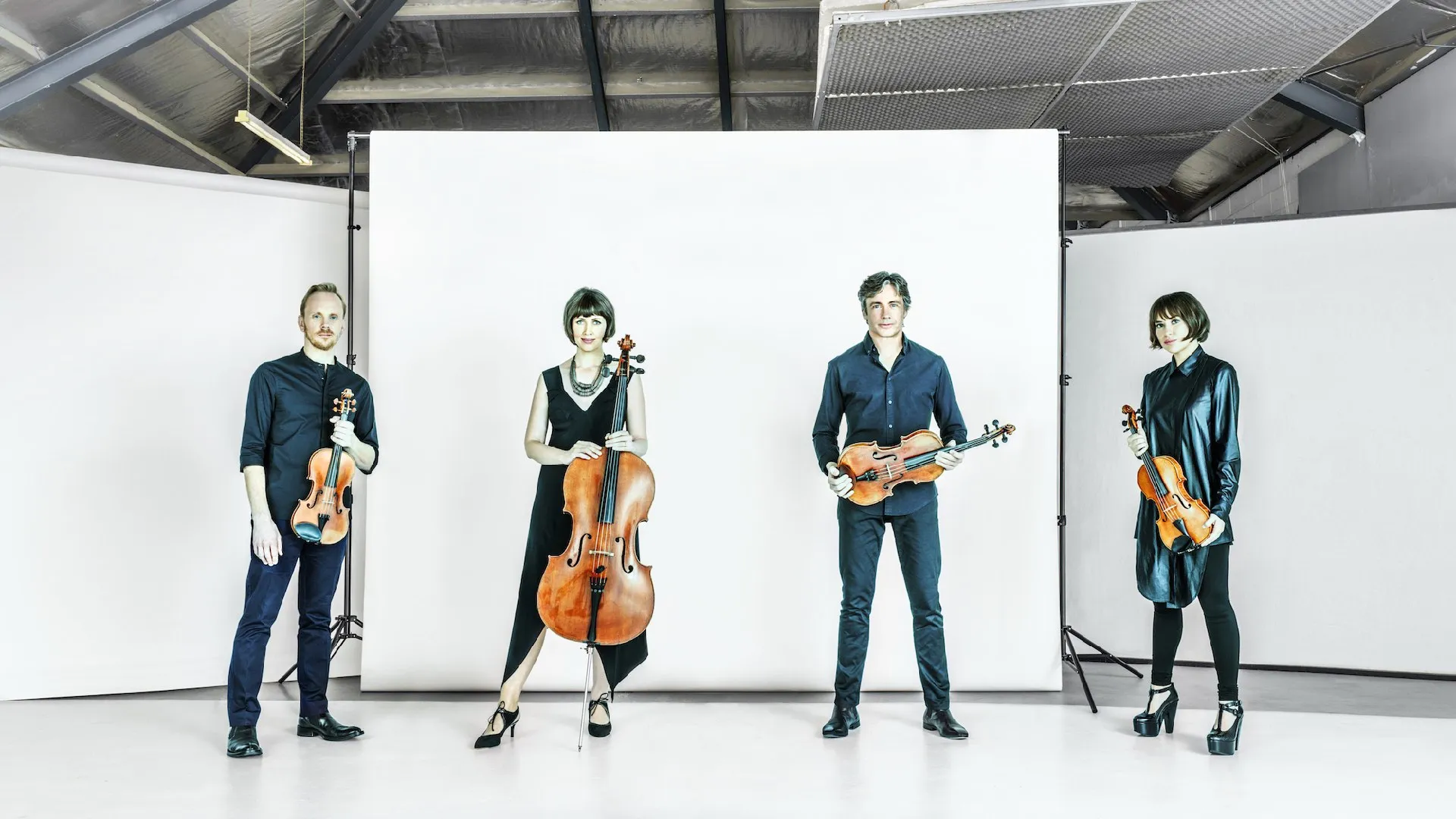 The Australian String Quartet standing in a line facing the camera.